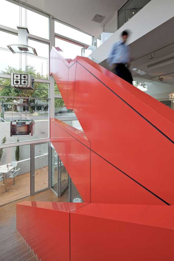 Wnętrze pełne inspiracji Wnętrze galerii designu Miele Santiago: nowoczesny design z czerwonymi akcentami i szklaną fasadą.