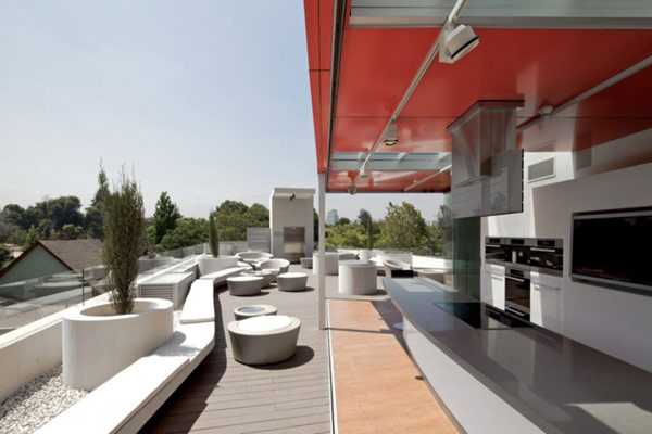 Gra świateł Santiago Galeria designu Miele Santiago: szklana fasada i czerwone akcenty w nowoczesnej architekturze komercyjnej.