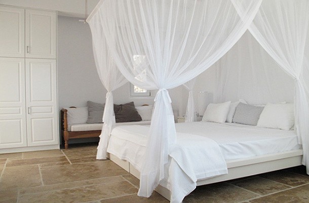 Baldachim nad Morzem Egejskim Łóżko z baldachimem w greckiej sypialni, błękit i naturalne materiały.