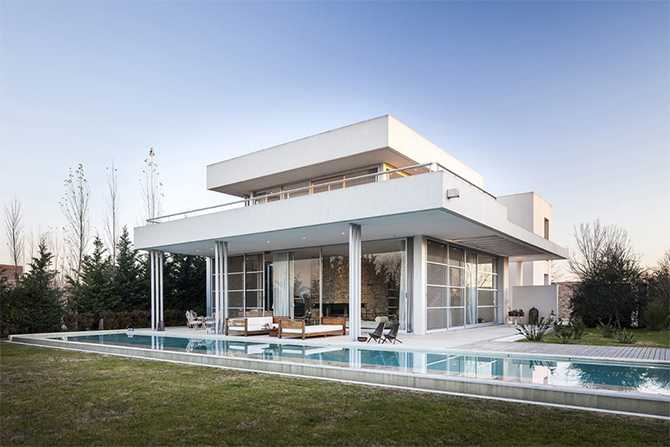 Dom: szkło i natura Nowoczesny dom z dużymi przeszkleniami i betonowymi elementami nad jeziorem – Kraków.