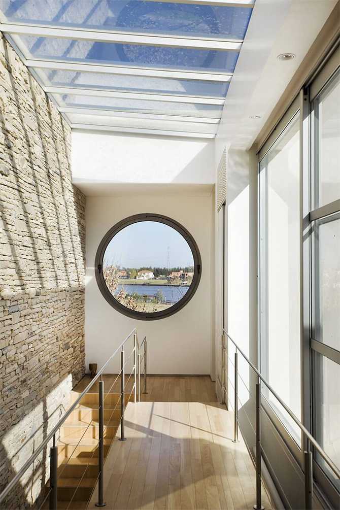 Okno na naturę Widok z okrągłego okna w nowoczesnym domu na malowniczy krajobraz, okolice Krakowa.