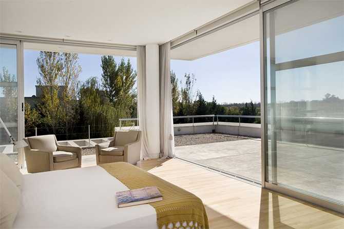 Sypialnia: eko-design Nowoczesna sypialnia w stylu eko z naturalnymi materiałami i dużym oknem w Krakowie.