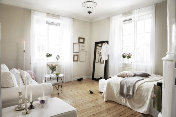 Sufit: Większa przestrzeń Jasny sufit optycznie powiększa kawalerkę: aranżacja salonu z sypialnią w minimalistycznym stylu.