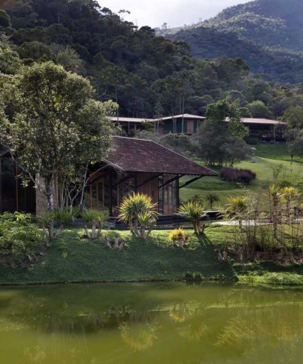 Widok na część salonu w brazylijskiej rezydencji z oświetleniem naturalnym i elementami drewna egzotycznego.