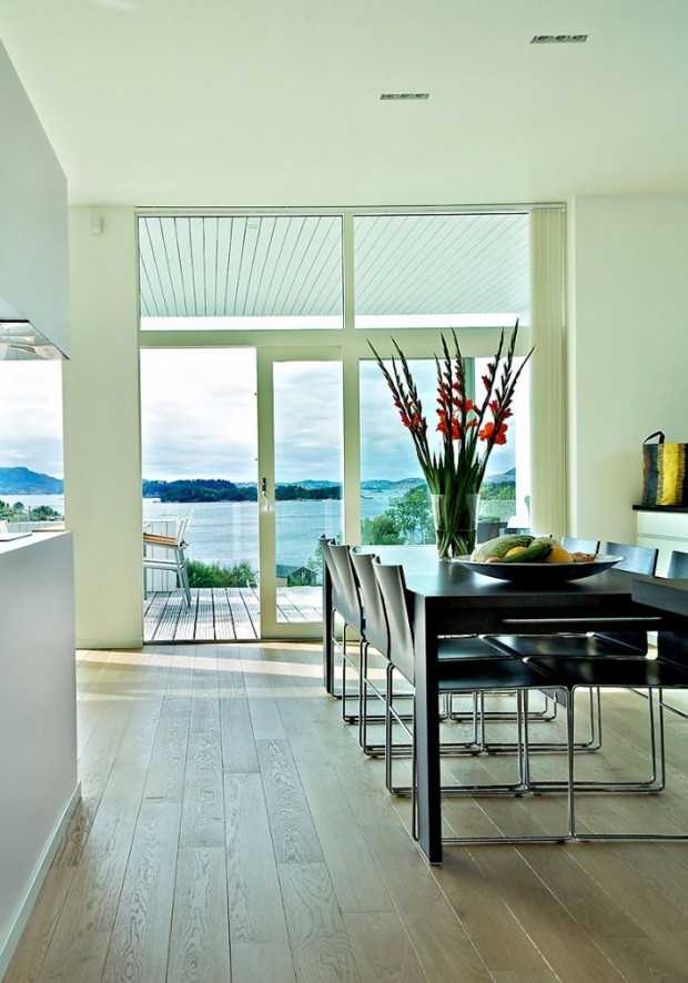 Ciepło kominka Pokój dzienny w norweskim domu z kominkiem, jasnymi kolorami i dużymi oknami