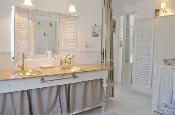 Złote dodatki w łazience Złote akcesoria łazienkowe: dozownik, mydelniczka i szczoteczka do zębów.