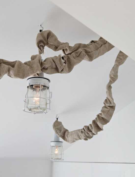 Akcenty w skandynawii Jasne wnętrze z elementami skandynawskiego designu: lampa podłogowa i rośliny.