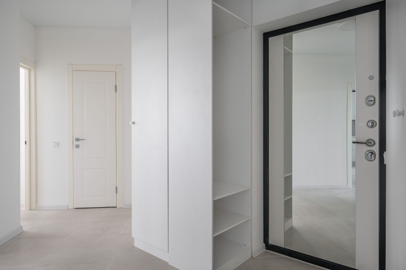 Przedpokój z lustrem Duże lustro na drzwiach wejściowych optycznie wydłuża przedpokój w kamienicy.