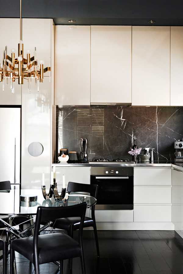 Jadalnia z charakterem Mieszkanie z duszą 2026: jadalnia z designerskim stołem i krzesłami przy ciemnych ścianach.