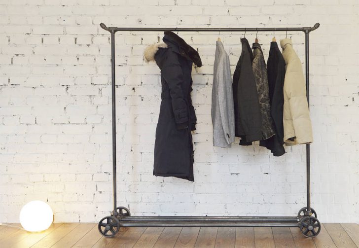 Wieszak na kółkach Przesuwna podłogowa wieszak-szczotka na kółkach na ubrania w nowoczesnym wnętrzu.