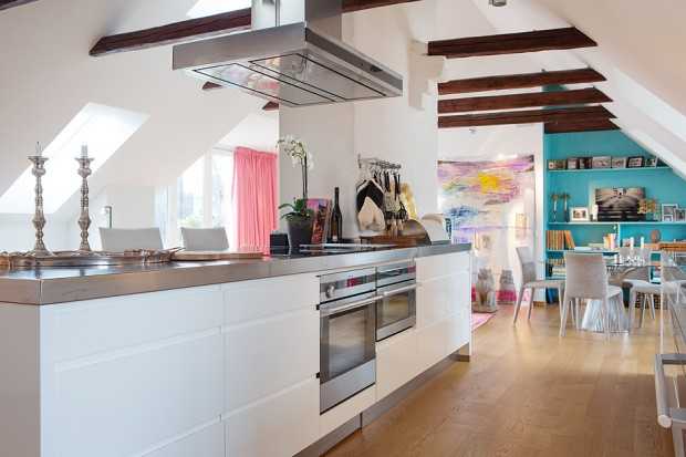 Jasny salon w stylu loft z sofą narożną i industrialnym oświetleniem, materac na lata.