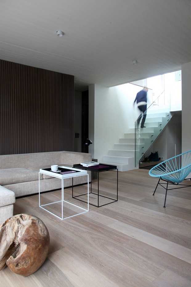 Światło i Drewno Oświetlenie naturalne w minimalistycznym wnętrzu greckiego penthousu, podkreślające drewniane elementy.