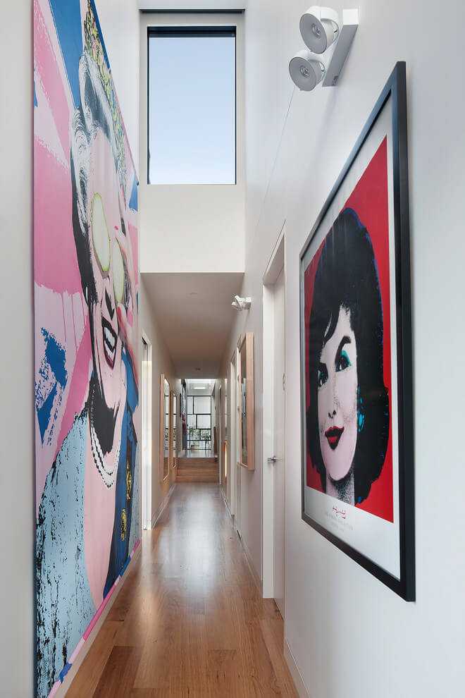 Galeria sztuki w domu Jasna galeria z wysokimi sufitami i obrazami w stylu pop-art na ścianach