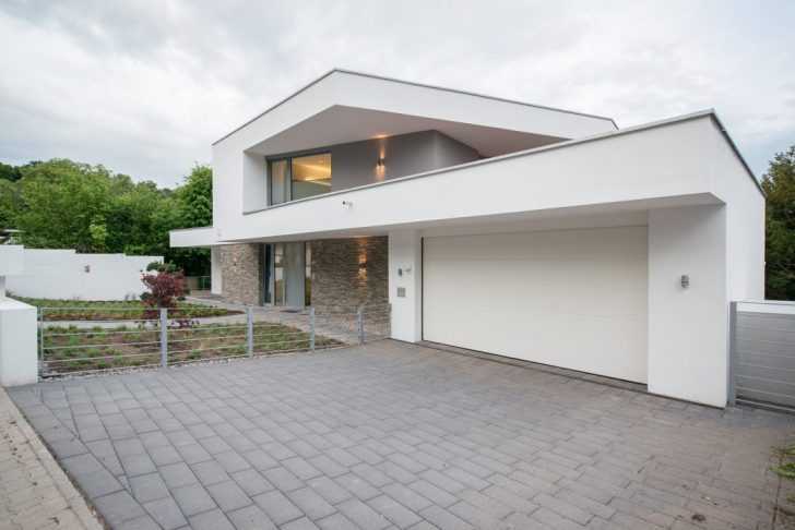 Wjazd do domu Podjazd do nowoczesnego domu trzypoziomowego na zboczu, wykończonego kamieniem.