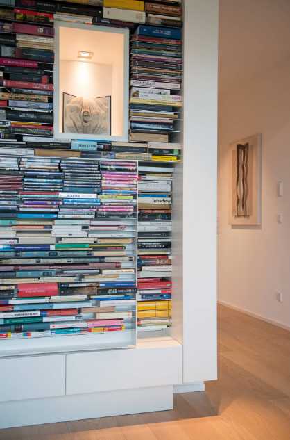 Biblioteczka w domu Półka na książki w nowoczesnym domu na zboczu, idealna dla miłośników literatury.