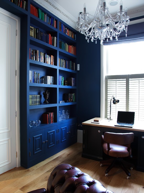 Elegancki Niebieski Gabinet Stylowy gabinet z ciemnoniebieskimi ścianami i drewnianymi elementami w stylu skandynawskim.