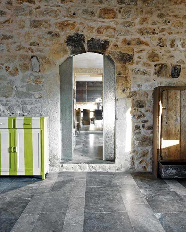 Sycylijska sypialnia w kamieniu Minimalistyczna sypialnia w rustykalnym stylu z kamiennymi ścianami w sycylijskim domu.