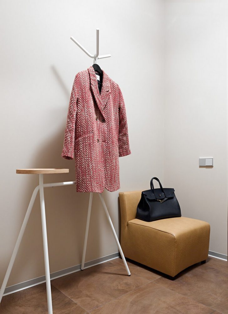 Wieszak Podłogowy: Mała przestrzeń Ergonomiczny metalowy wieszak podłogowy oszczędzający przestrzeń w małej kawiarni.