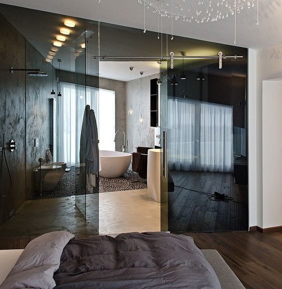 Szklana Wanna: Nowoczesność Wanna w sypialni oddzielona szklaną ścianą, zapewniająca intymność i nowoczesny wygląd.