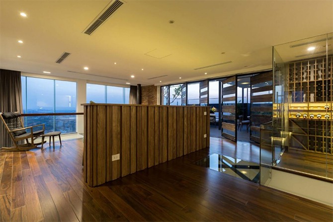 Winnica w apartamencie Winnica z półkami na butelki wina obok schodów w dwupoziomowym apartamencie.