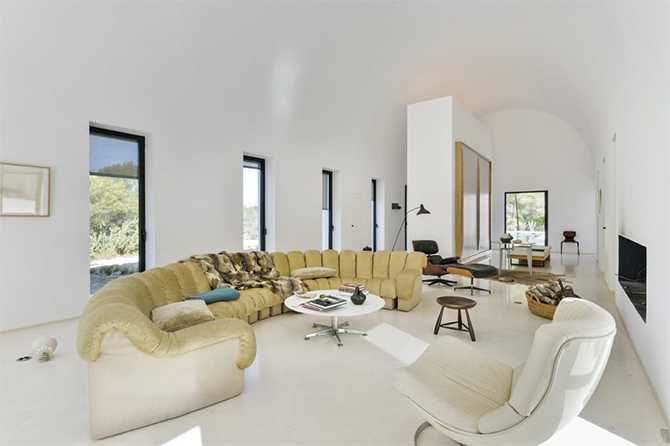 Ibizkański salon w bieli Salon w willi na Ibizie: minimalistyczny design, rustykalne elementy i białe tynki.