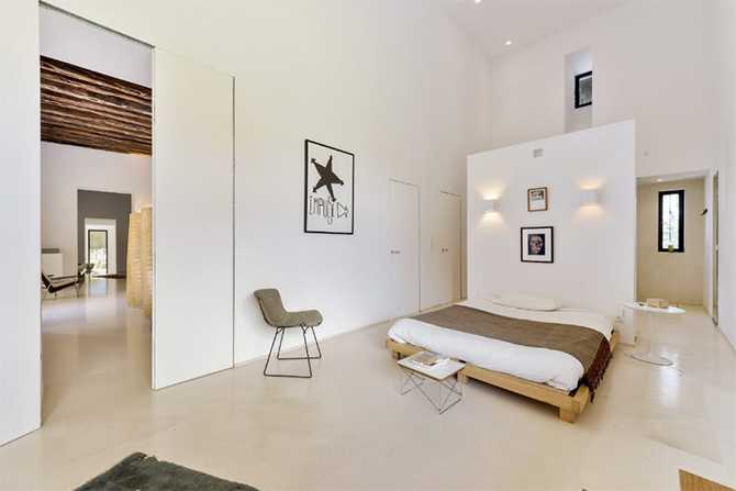 Ibizańska Elegancja Sypialni Elegancka sypialnia główna na Ibizie z elementami rustykalnymi i nowoczesnym designem.