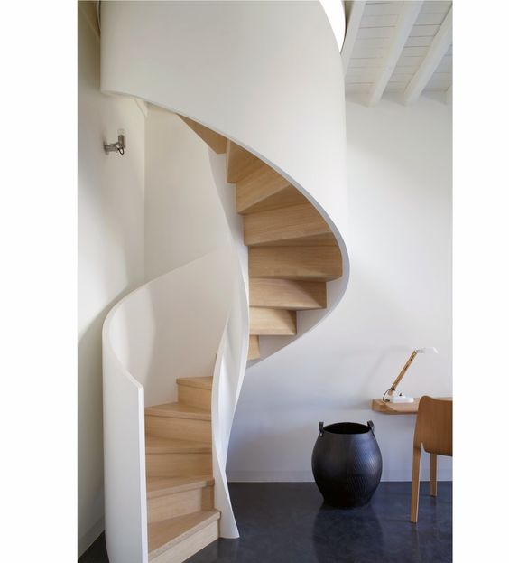 Spiralne schody metalowe Nowoczesne schody spiralne metalowe w jasnym wnętrzu domu, elegancki design