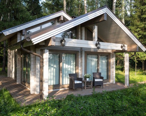 Klasyka skandynawskiego domu Klasyczny dom skandynawski z ciemnym dwuspadowym dachem i jasną elewacją